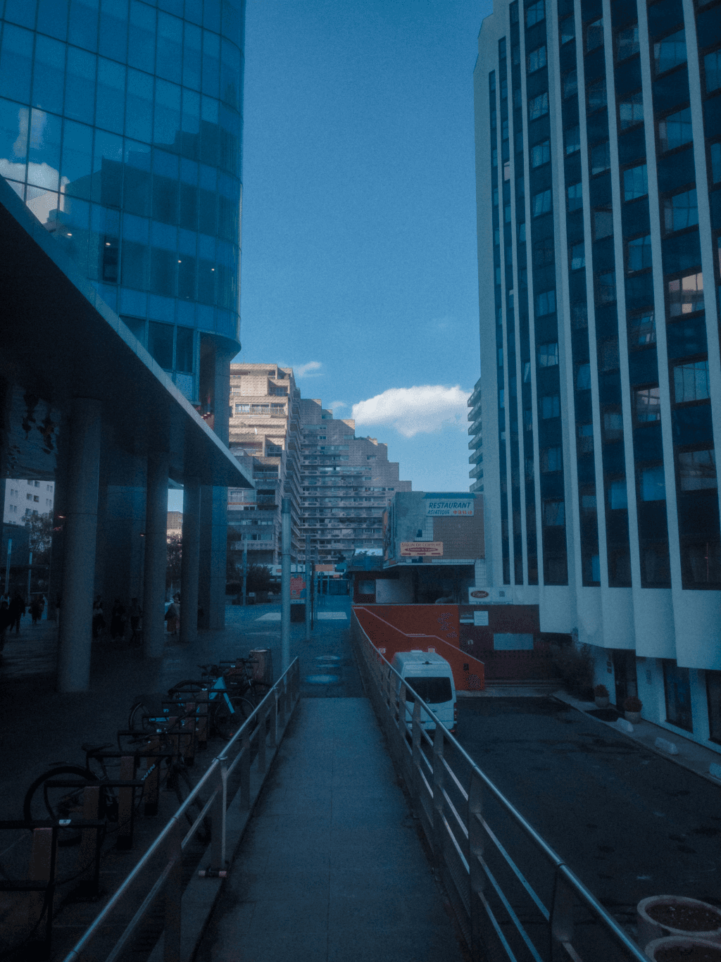 Picture of a brutalis building lit amongst blue skyscrapers